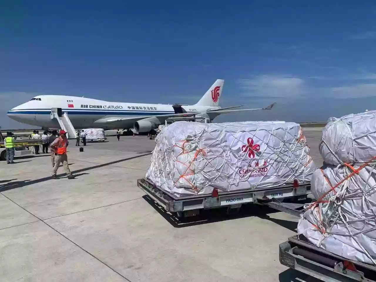 Chinese and Cambodian flags side by side in front of a warehouse